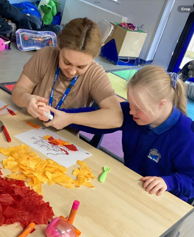 Teacher helping a female student with art project